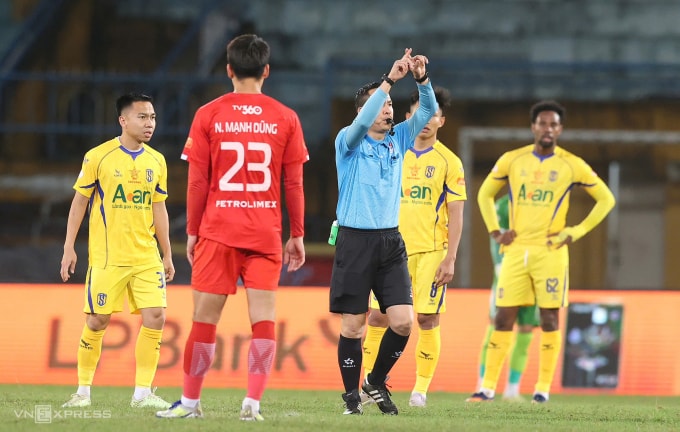 Trọng tài Nguyễn Viết Duẩn (áo xanh lam) bắt chính trận Thể Công thua SLNA 1-4. Ảnh: Hoàng Huynh