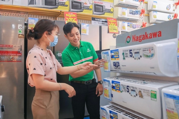 Nhân viên bán hàng đang tư vấn sản phẩm máy lạnh tại một cửa hàng điện máy. Ảnh: NAG