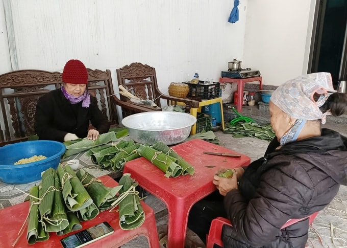 Bà Vũ Thị Thúy (69 tuổi) thoăn thoắt xếp lá, đổ gạo rồi gấp mép tạo hình bánh chưng. Ảnh: Lê Tân