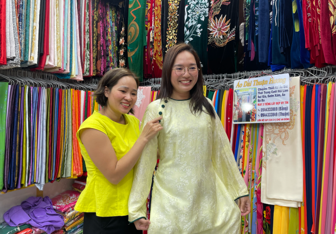 Chị Nguyễn Thị Thuận thử áo dài cho khách ở chợ An Đông, phường An Đông, TP HCM, trưa 9/2. Ảnh: Ngọc Ngân