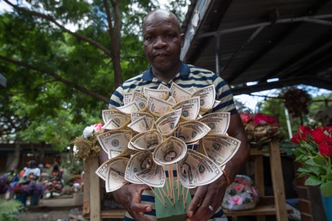 Florist Tongai Mufandaedza holds a money bouquet designed for Valentines Day at his stall in Harare, Zimbabwe, Tuesday, Feb. 10, 2026. (AP Photo/Aaron Ufumeli)