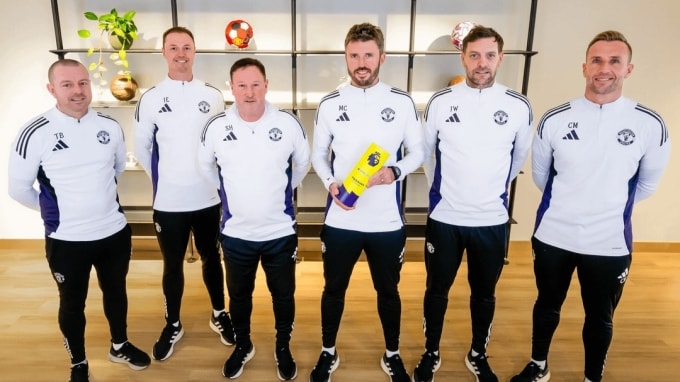 Carrick cầm giải thưởng tháng 1/2026 ở Ngoại hạng Anh, bên cạnh các thành viên ban huấn luyện Man Utd. Ảnh: Man Utd