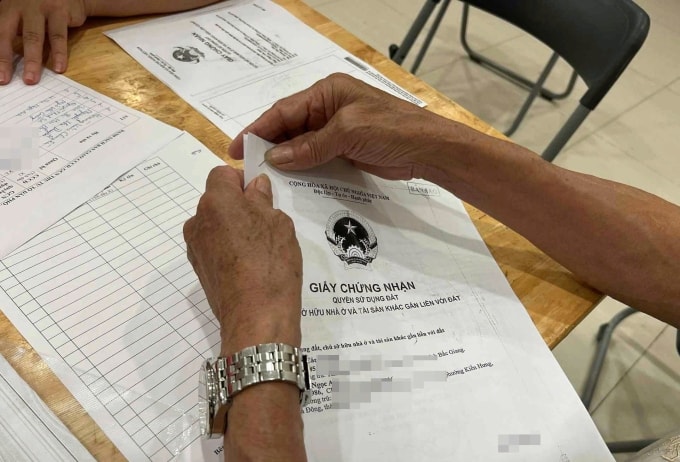 Người dân nộp sổ đỏ photocopy trong quá trình làm giàu, sạch dữ liệu đất đai. Ảnh: Linh Đan