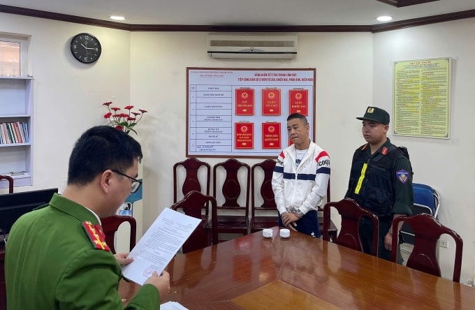 Công an đọc lệnh khởi tố với Tuấn. Ảnh: Công an cung cấp