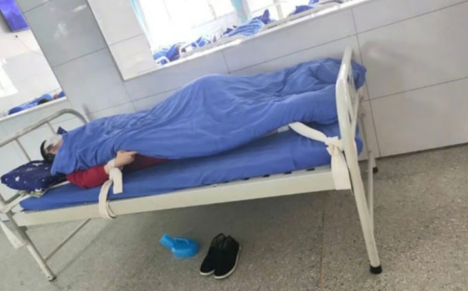 Một bệnh nhân tại Bệnh viện Tâm thần Khang Ninh Di Lăng (Nghi Xương) bị trói chặt vào giường bệnh suốt gần một ngày đêm vì xảy ra tranh cãi với nhân viên tại đây. Ảnh: Beijing News