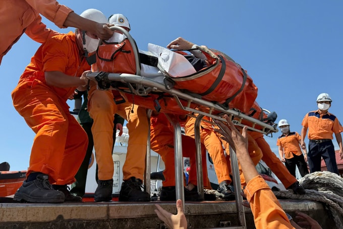 Nhân viên tàu SAR 274 chuyển bệnh nhân từ tàu xuống bờ. Ảnh: DNMRCC