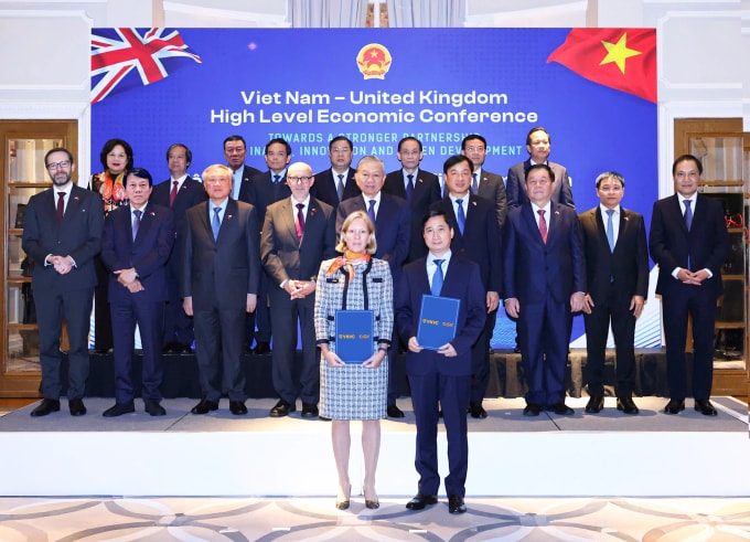 Tổng Bí thư Tô Lâm (thứ 5 hàng thứ hai từ trái qua), Đặc phái viên Thương mại của Chính phủ Anh Matt Western (thứ 4 hàng thứ hai từ trái qua) chứng kiến ông Ngô Chí Dũng, Chủ tịch Hội đồng quản trị kiêm Tổng giám đốc Công ty Vaccine Việt Nam VNVC và bà Kaja Natland, Phó Chủ tịch cấp cao GSK vùng châu Á - Thái Bình Dương, khu vực quốc tế, trao văn kiện hợp tác, hôm 31/10/2025. Ảnh: HTN