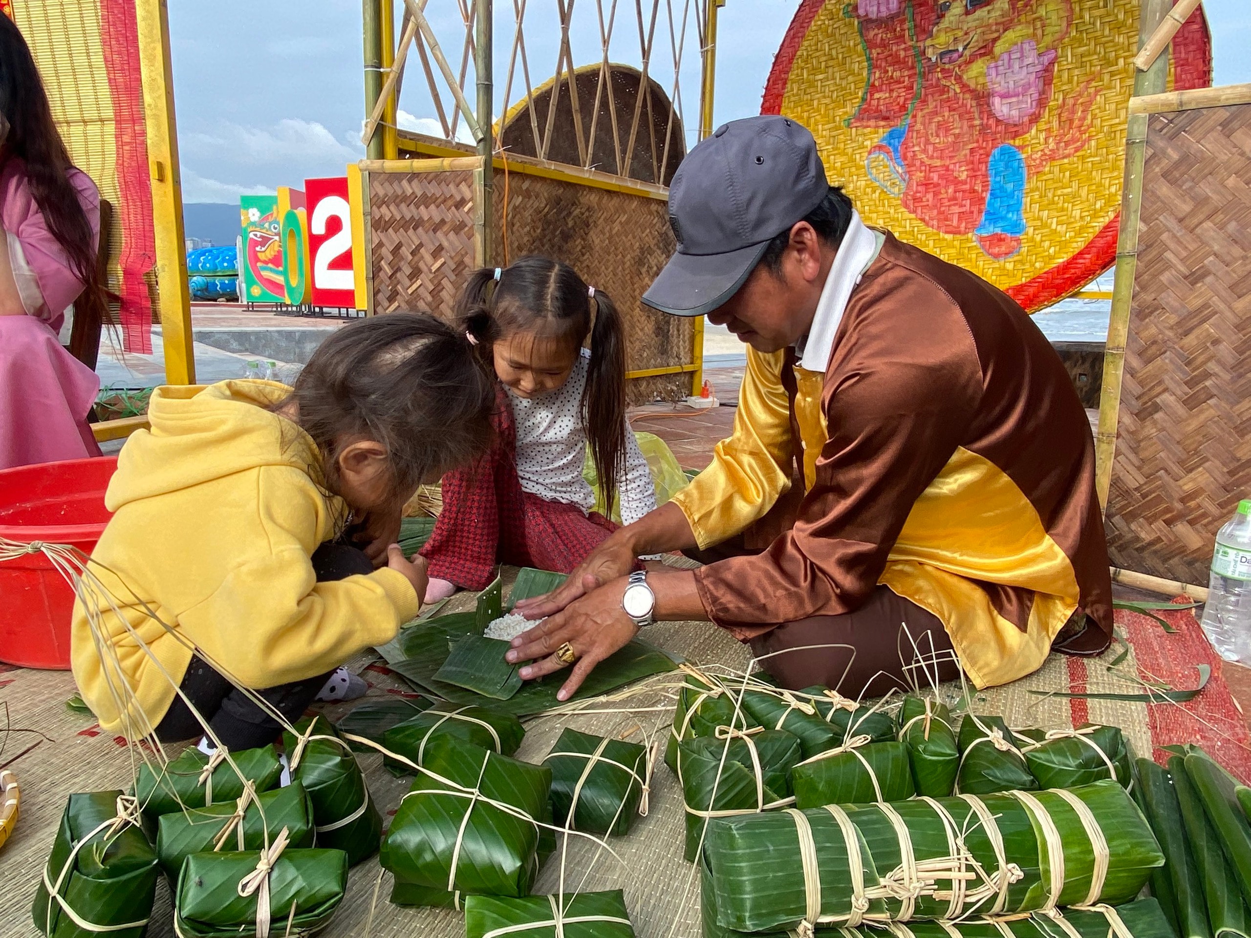 Du khách nước ngoài tập gói bánh chưng bên bãi biển Đà Nẵng- Ảnh 2.
