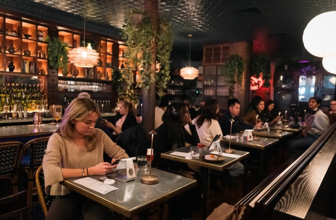 Quán bar được thiết kế cho các bàn đơn, có giá đỡ iPhone để khách giao tiếp cùng AI. Ảnh: NY Post