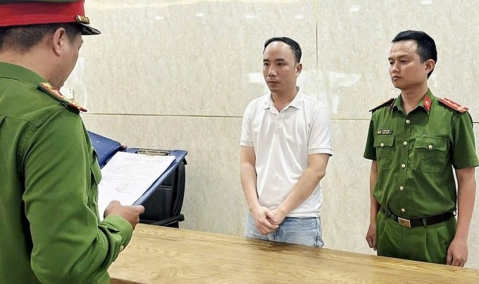 La Thế Quang (áo thun) nghe cảnh sát đọc lệnh bắt tạm giam. Ảnh: Công an Đà Nẵng