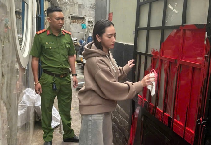 Phạm Ngọc Mỹ Tiên bị cảnh sát yêu cầu lau các vết sơn. Ảnh: Công an TP HCM