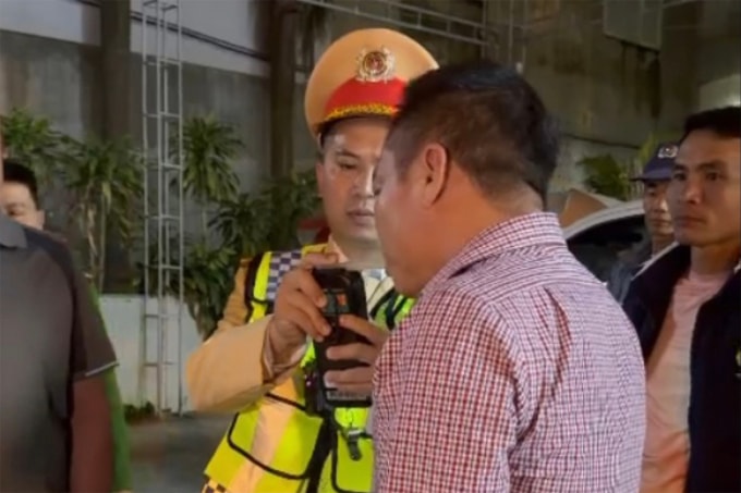 Tài xế (mặc áo sọc), phải xuống đo nồng độ cồn sau khi thách thức cảnh sát giao thông. Ảnh: Công an cung cấp