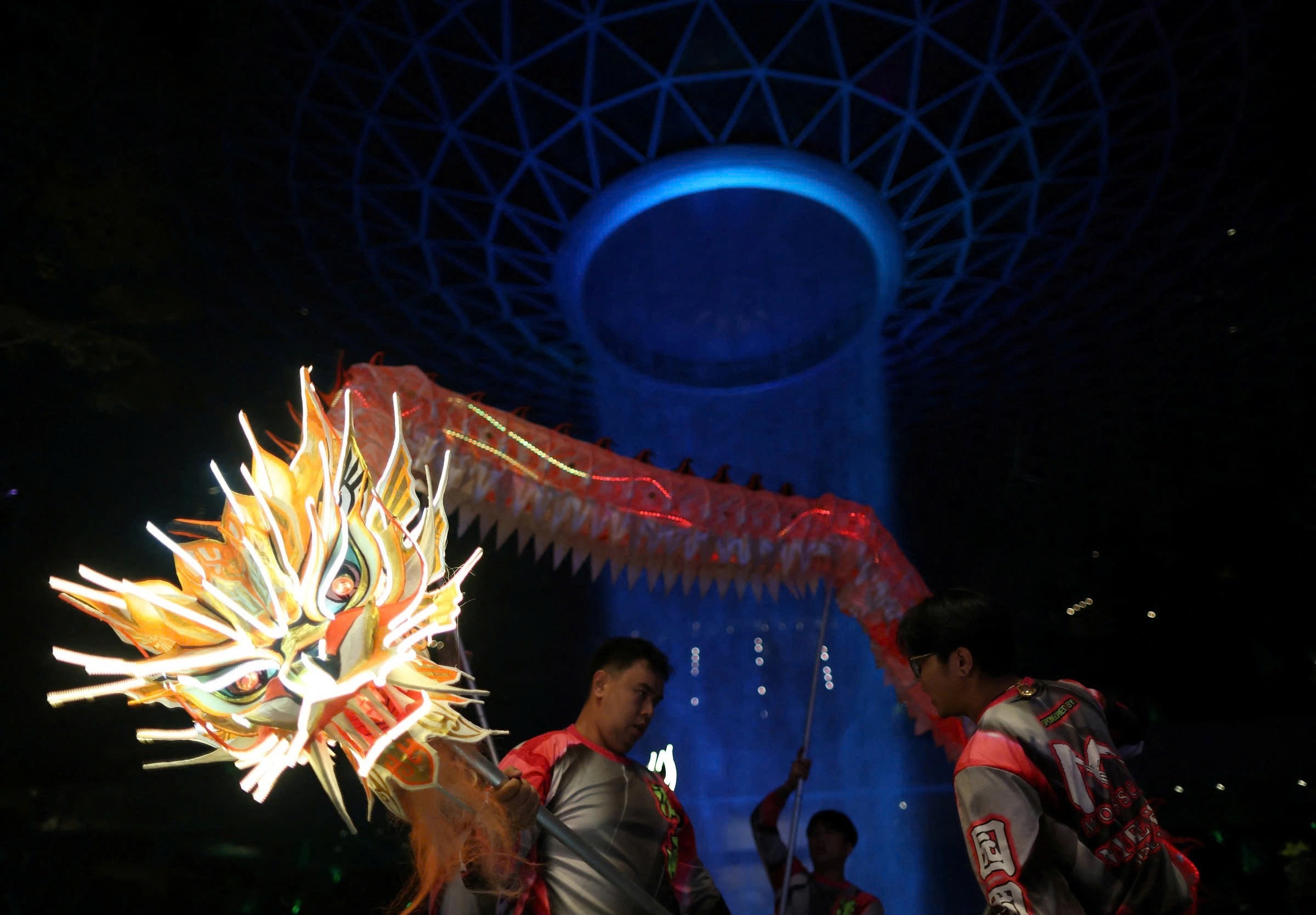 Tại Singapore, trước thời khắc chuyển giao năm cũ sang năm mới, đoàn nghệ sỹ biểu diễn vũ điệu rồng đèn LED có mặt tại khu Jewel Changi thuộc sân bay Changi để chuẩn bị cho màn biểu diễn chào năm Bính Ngọ. (Ảnh: Reuters)