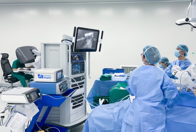 Phó giáo sư Vĩnh (ngoài cùng bên trái) điều khiển robot Da Vinci Xi phẫu thuật cắt u phổi cho bà Vân. Ảnh: Bệnh viện Đa khoa Tâm Anh