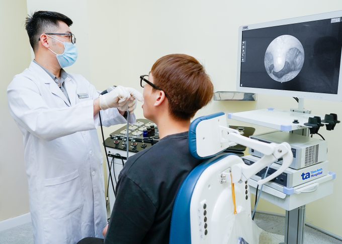 Bác sĩ Long đang nội soi họng cho một người bệnh. Ảnh: Bệnh viện Đa khoa Tâm Anh