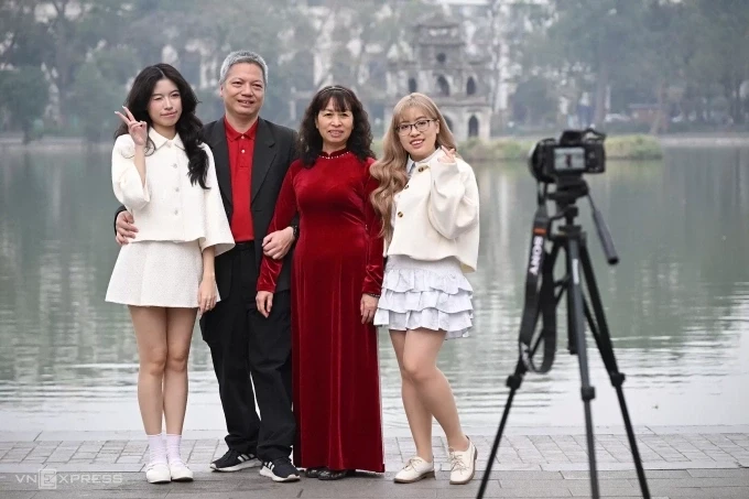 Gia đình anh Hoàng Tuấn Anh giữ truyền thống bao năm cùng nhau lên Hồ Gươm vào mùng 1 Tết để chụp ảnh với tháp Rùa. Ảnh: Giang Huy