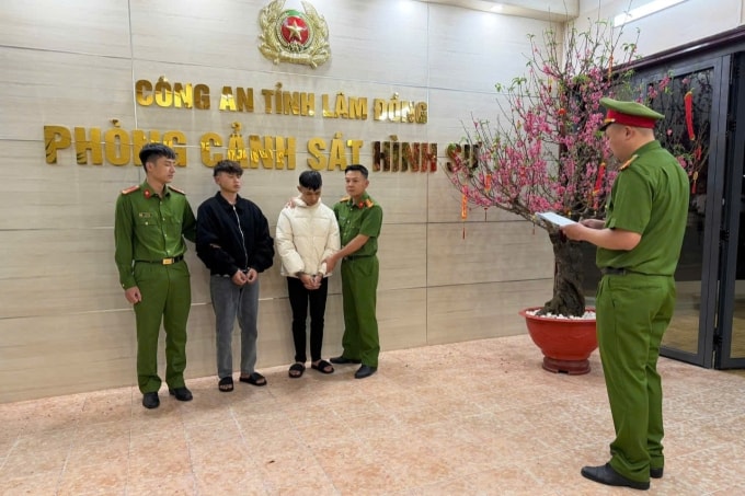 Hai nghi phạm cướp tiệm vàng Kim Lượng nghe cảnh sát đọc lệnh bắt giữ, tối 17/2. Ảnh: Công an cung cấp