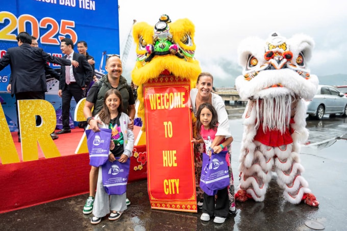 Khách quốc tế chụp ảnh cùng đội múa lân khi đến Huế. Ảnh: Võ Thạnh