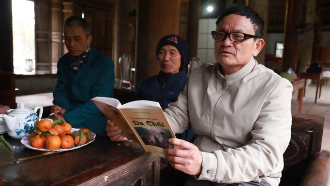 Ông Nguyễn Văn Phường, 66 tuổi, người làng Đa Chất đang đọc sách tài liệu về ngôn ngữ của làng, tháng 1/2026. Ảnh: Quỳnh Nguyễn