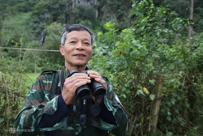 Ông Nguyễn Thanh Tú dùng ống nhòm quan sát đàn voọc mỗi ngày. Ảnh: Đắc Thành