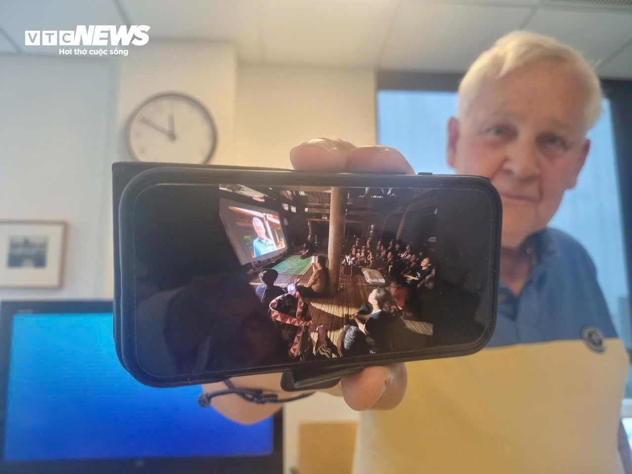 Hai nhà báo chiếu các bức ảnh cho người dân ở làng xem.