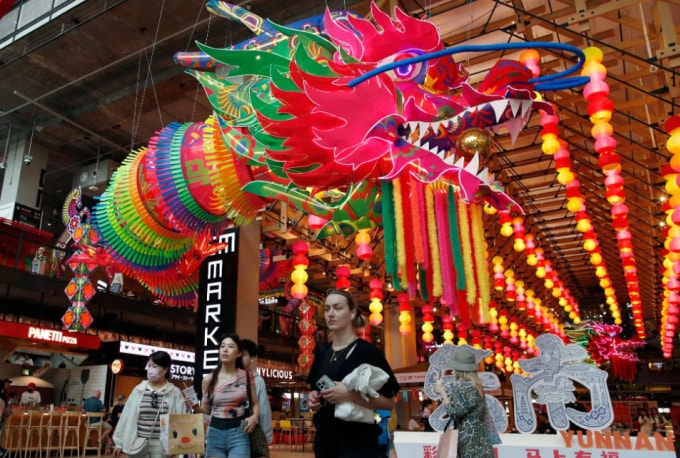 Mọi người đi ngang qua tiểu cảnh trang trí dịp Tết Nguyên đán tại một trung tâm thương mại ở Bangkok ngày 14/2. Ảnh: EPA