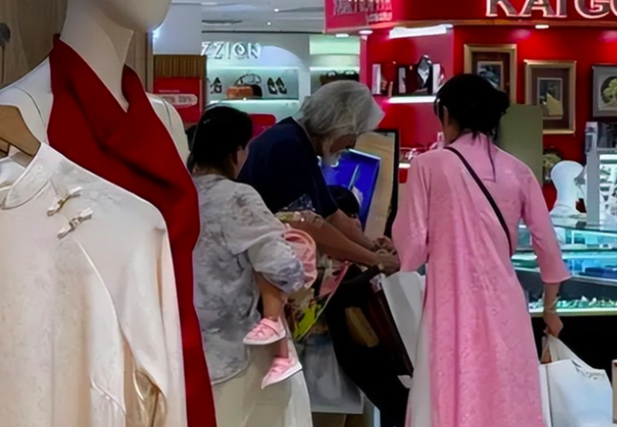 Đạo diễn Trương Kỷ Trung và vợ con mua sắm tại TP HCM. Ảnh: Sina