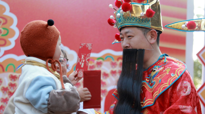 Một em bé ở Quảng Đông, Trung Quốc nhận lì xì dịp Tết Nguyên đán 2026. Ảnh: Liu Ranyang/CNS/VCG
