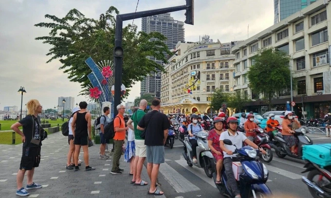 Du khách chờ sang đường ở đoạn đèn tín hiệu không hoạt động trên đường đường Tôn Đức Thắng, TP HCM. Ảnh: Bích Phương