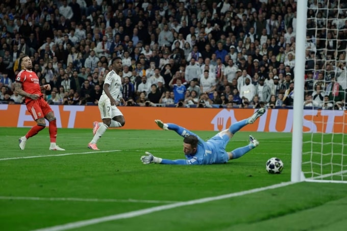 Vinicius (áo trắng) ấn định chiến thắng trận Real 2-1 Benfica ở lượt về vòng play-off Champions League tối 25/2. Ảnh: AS