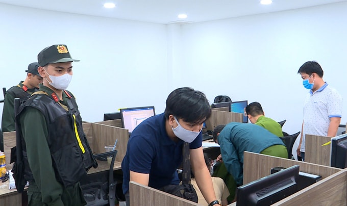 Cảnh sát khám xét, thu thập dữ liệu tại trụ sở của nhóm lừa. Ảnh: Nhật Vy