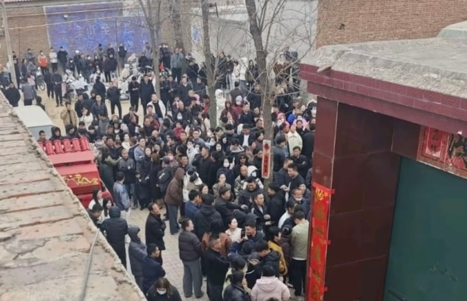 Nhà trai đưa xe pháo đến trước cửa nhà gái, thu hút đông người đứng xem. Ảnh: Weibo