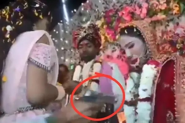 Người đàn ông cầm súng bắn cô dâu Aarti Kumari trong nghi thức trao vòng hoa. Ảnh: Guwahati