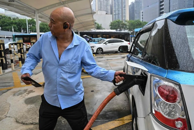 Một tài xế taxi sạc xe điện tại trạm sạc Antuoshan ở Thâm Quyến, tỉnh Quảng Đông, miền nam Trung Quốc, ngày 18/10/2023. Hector Retamal/AFP)*