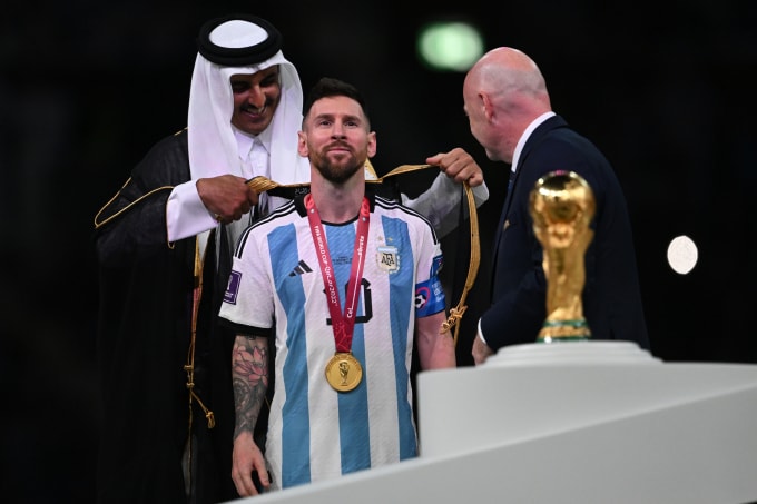 Tiểu vương Qatar (trái) khoác áo choàng Hồi giáo lên Messi sau khi Argentina vô địch World Cup 2022 ngày 18/12/2022. Ảnh: AFP