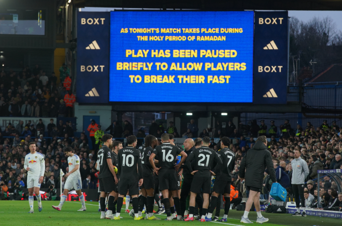 HLV Pep Guardiola tranh thủ hội ý, khi trận Man City gặp Leeds ở vòng 28 Ngoại hạng Anh tạm dừng để các cầu thủ bổ sung nước và vitamin do đang trong tháng Ramadan. Ảnh: AFP