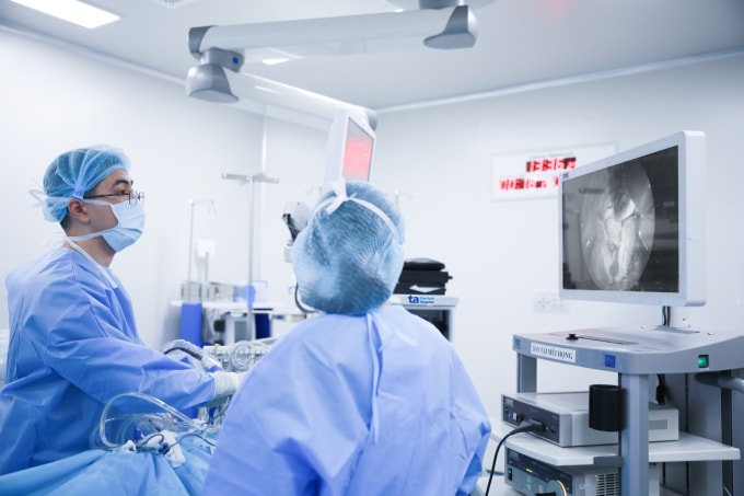 Bác sĩ Hữu (trái) đang phẫu thuật mũi xoang bằng nội soi cho bà Thân. Ảnh: Bệnh viện Đa khoa Tâm Anh