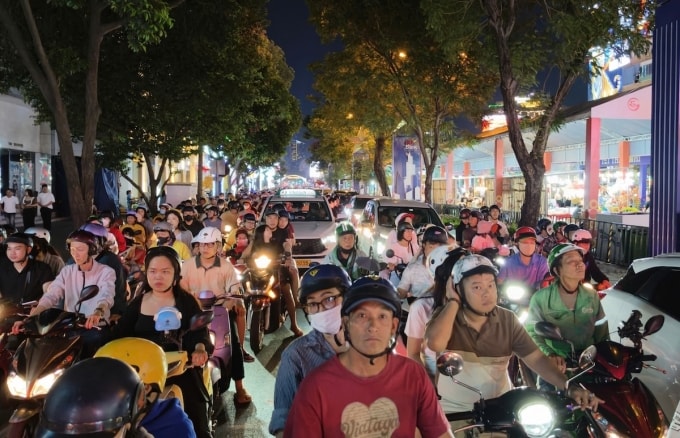 Dòng xe máy, ôtô ùn tắc trên tại hai làn đường hỗn hợp Lê Lợi vào tối 16/2, lúc này 6 làn đường ở giữa đang dựng rạp tổ chức sự kiện văn hoá- ẩm thực. Ảnh: Đình Văn