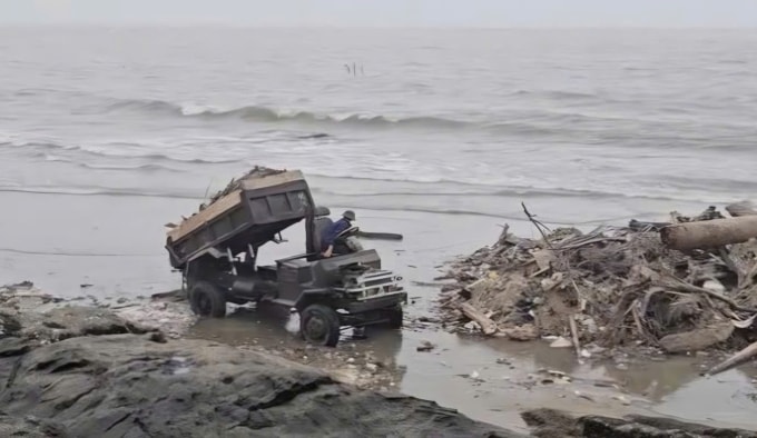 Một trong số ô tô tải đang đổ rác thải xuống gần mũi Hòn Bò. Ảnh cắt từ clip