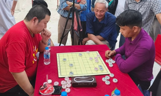 Vương Hạo (trái) trong một ván đấu tại giải cờ tướng hội làng Đông Lao, xã An Khánh, Hà Nội ngày 2/3/2026. Ảnh: Nhất Chi Mai