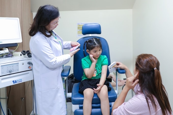 Bé Dung, 4 tuổi, ra dấu hiệu nghe được âm thanh sau 1 tháng cấy điện cực ốc tai. Ảnh: Bệnh viện cung cấp