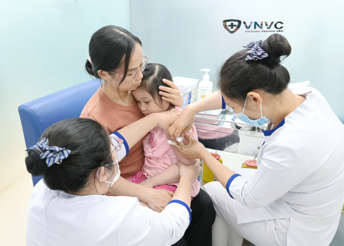 Chị Hương đưa con gái 5 tuổi đi tiêm nhắc vaccine cúm và thương hàn tại VNVC Tân Thuận. Ảnh: Hoàng Dương