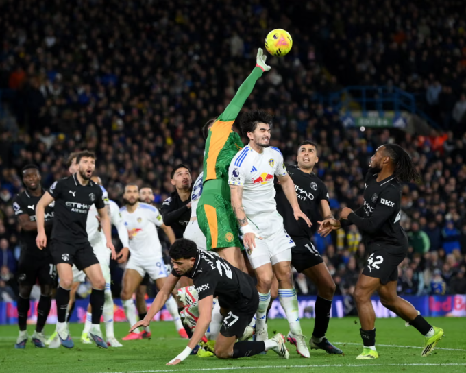 Gianluigi Donnarumma phá bóng trong trận gặp Leeds. Ảnh: Reuters