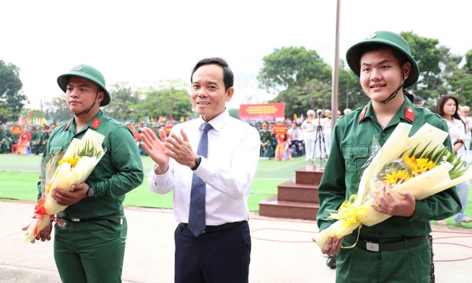 Bí thư Thành ủy TP HCM Trần Lưu Quang tặng hoa cho thanh niên lên đường nhập ngũ. Ảnh: An Phương