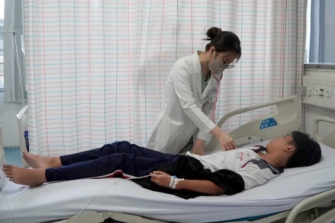 Bác sĩ khám cho một bệnh nhân nghi ngộ độc sau khi ăn bánh mì ở tiệm trên đường Đồ Chiểu. Ảnh: Minh Bằng