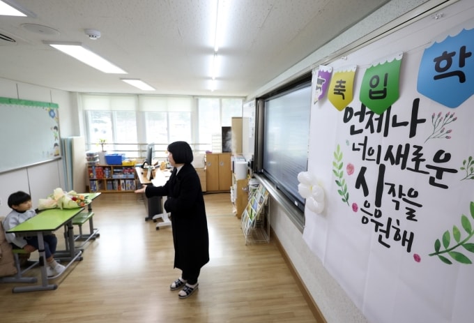 Bé Kang trong lớp học cùng cô giáo chủ nhiệm. Ảnh: Yonhap