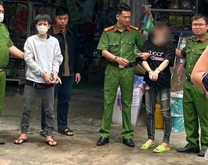 Bảo (áo xám) cùng Vũ bị công an đưa đi thực nghiệm hiện trường. Ảnh: Công an cung cấp