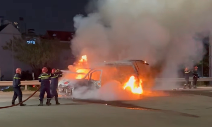 Lính cứu hoả kéo vòi rồng dập lửa ôtô cháy. Ảnh: Minh Bằng