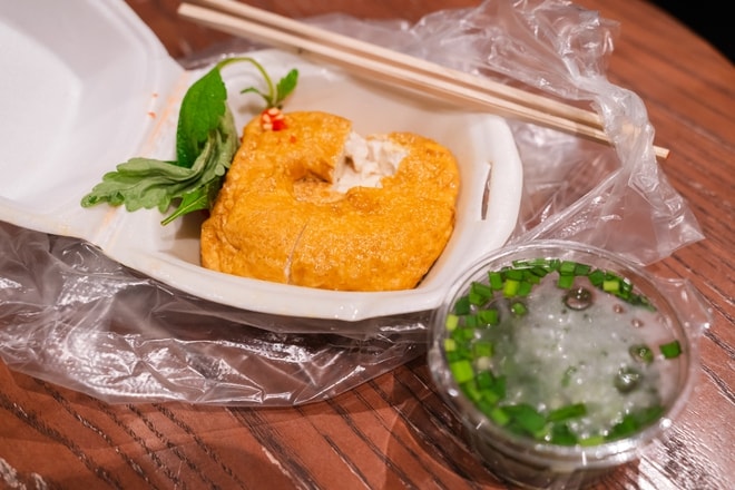 VIDEO: Người dân TPHCM đội mưa, xếp hàng chờ mua đậu hũ vàng chấm muối hẹ "mỗi năm chỉ bán một lần" - Ảnh 2.