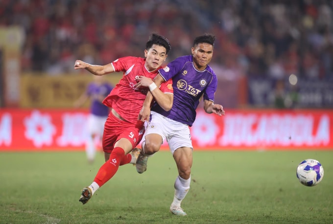 Tiền đạo Công an Hà Nội Nguyễn Đình Bắc (áo đỏ) bị các cầu thủ Hà Nội FC chăm sóc kỹ lưỡng. Ảnh: VPF